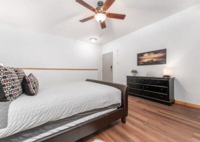 Loft Bedroom with ceiling fan and dark dresser