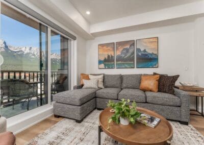 grey couch against patio glass doors showing mountains outside